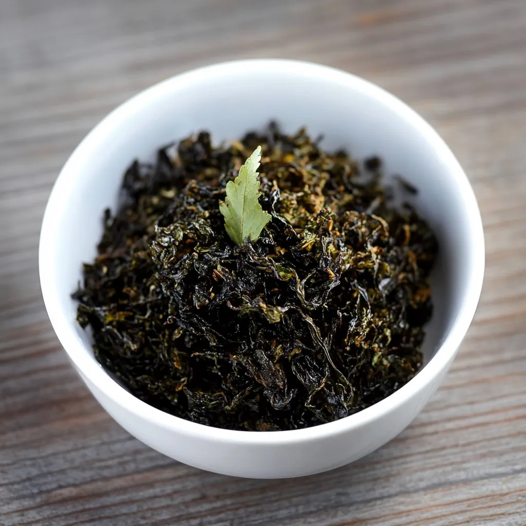 Um prato de café verde com uma folha de erva no centro.